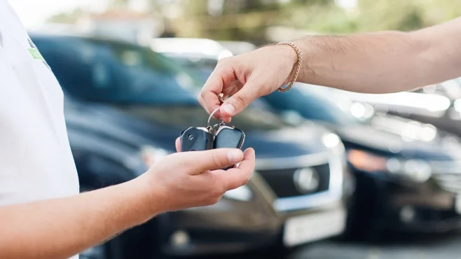 A person handing over the limousine car key to another person