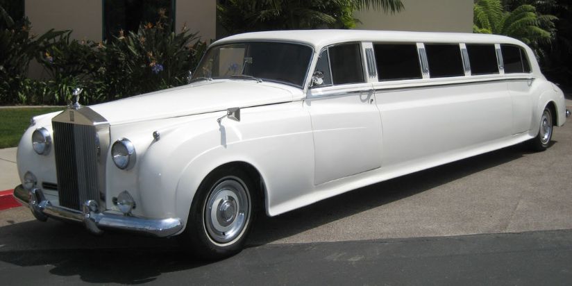 The classic vintage limo is parked next to a rich house