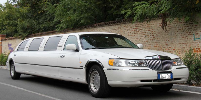 The lincoln limo is parked next to a side of the road