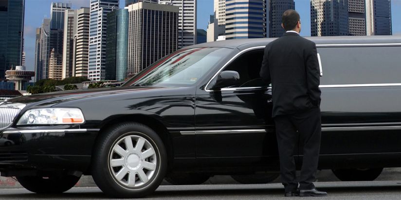 Chauffeur standing with beautiful black limo