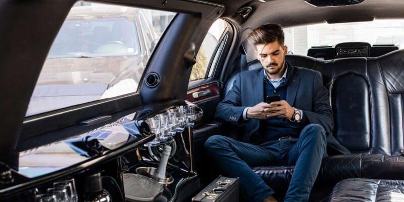 A corporate guy sitting in a limousine